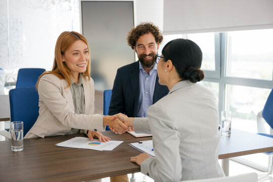Business partners shaking hands in modern office after agreement
