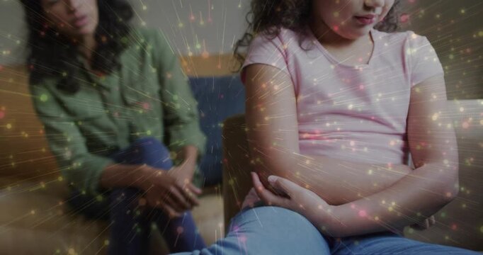 Soothing woman leaning, child in pink shirt uncrossing arms and smiling on home couch with sparkles