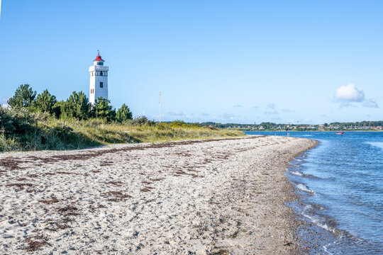 Lighthouse on sandy beach at Sophi�odde F�nen Denmark under blue sky