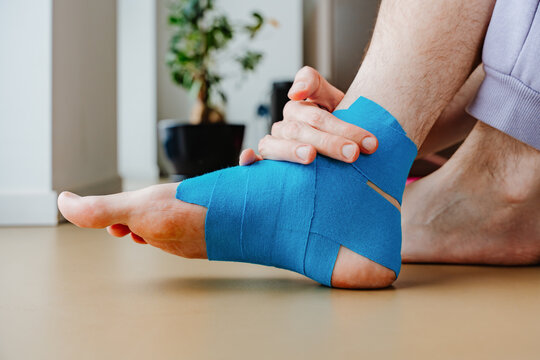 Wrapping Foot With Kinesiology Tape For Injury