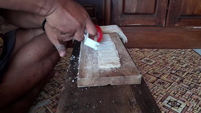 The process of manually cutting raw dumplings before frying, a traditional Indonesian snack.