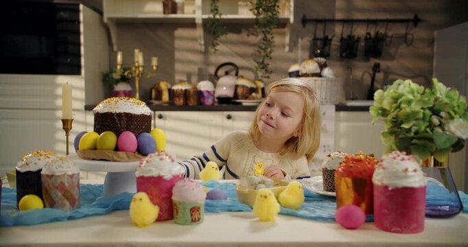 Little boy examining yellow chick at Easter table
