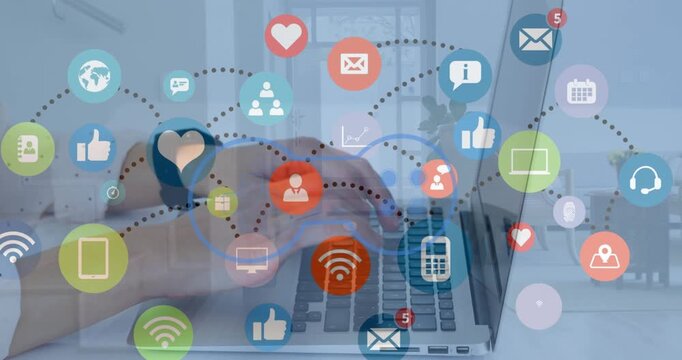 Animation of game controllers, connected icons over cropped hand of caucasian man working on laptop