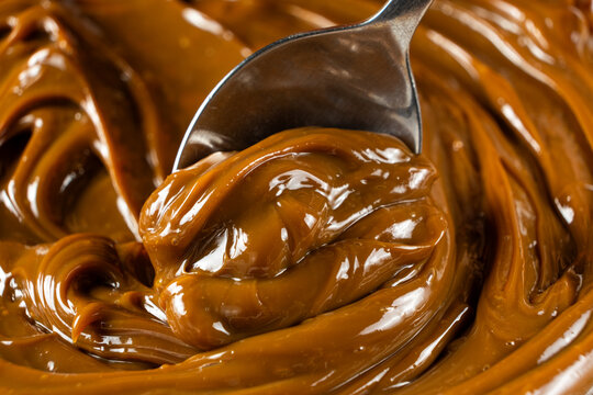 Dulce de leche on a spoon, thick boiled condensed milk