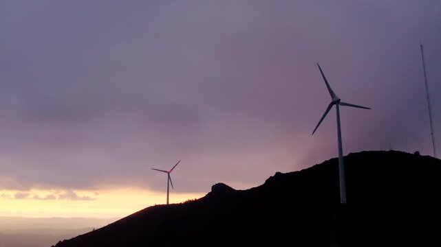 Wind turbines at Serra da Boneca in Penafiel Porto District Norte Portugal on exposed ridge in Iberian Peninsula European Union setting, slow drone forward glide