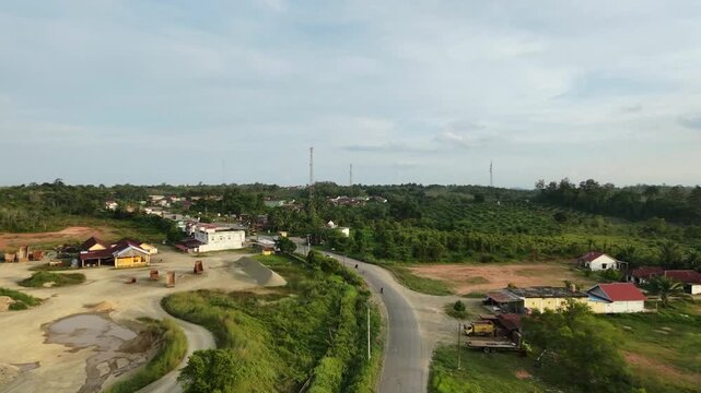 Aerial view of a semi-rural landscape with winding roads, scattered houses, greenery and construction areas, ideal for travel, environmental and architecture themes.