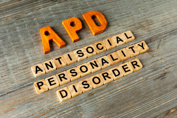 Naklejka premium APD abbreviation on wooden letters and its individual words: Antisocial Personality Disorder, spelled out with wooden letter tiles on aged wooden boards.