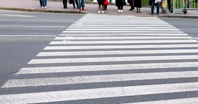 Waiting for pedestrians near a pedestrian crossing with painted white stripes. Traffic rules for drivers and pedestrians.