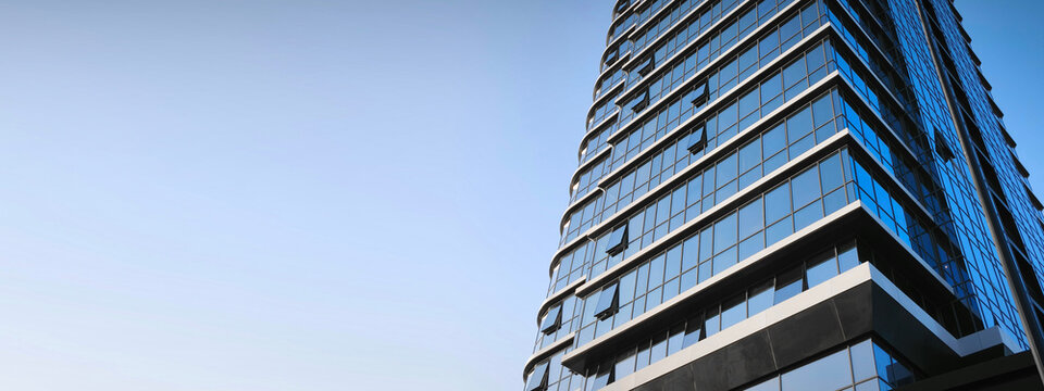 Eco-friendly building in modern city. Sustainable glass office building with trees for reducing CO2. Green architecture. Building with green environment. Sustainability corporate. Net zero emissions.