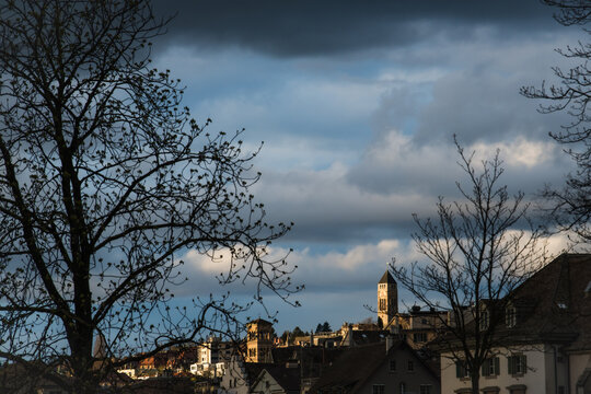 Zurich, Switzerland - 02 April 2023: View of the city skyline, where the Grossmunster cathedral stands tall against a backdrop of dramatic, cloud-strewn skies.