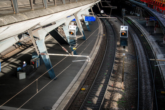 Zurich, Switzerland - 02 April 2023: View of the sleek, modern train station platforms curving gently into the distance, with silver metal supports contrasting against the dark, gritty tracks.