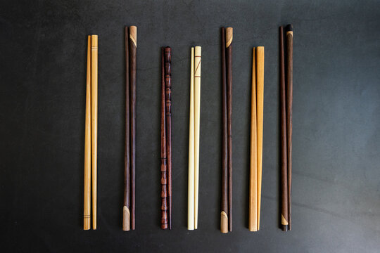 Variety of chop sticks on a dark surface