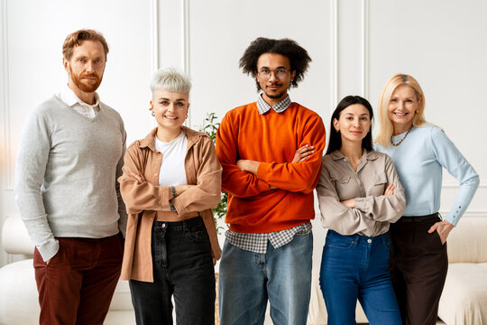 Diverse business team standing together in office looking at camera