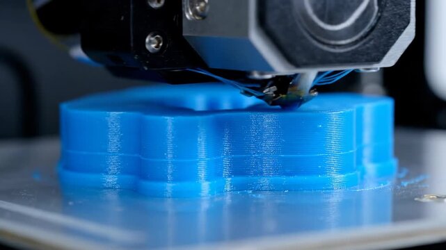 Close up 3D printer creating blue object, technology and innovation concept.