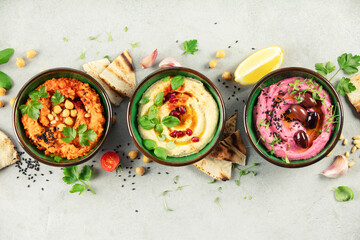 Colorful Hummus Trio with Garnishes and Pita Bread © Natalia Klenova