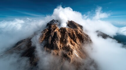 Obraz premium A breathtaking aerial view of a majestic volcano erupts, surrounded by clouds and set against a vibrant blue sky, capturing the sheer power of nature's forces in motion.