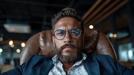 Fototapeta premium A man with an intense gaze sits thoughtfully in a modern office, embodying confidence and professionalism while showcasing a striking personal style.