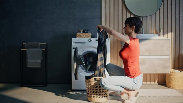 Housewife unloading washing machine home laundry. Lady working domestic chores