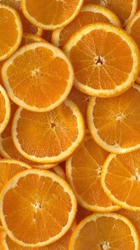 Top view of unpeeled orange slices as a background texture. Vertical video.
