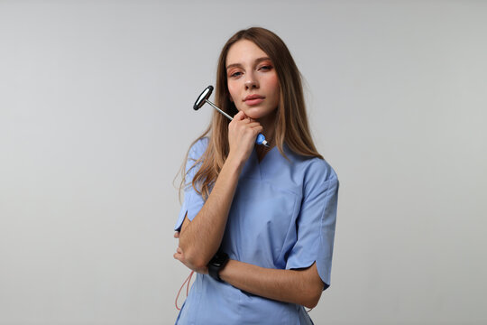 Young clinician posing with reflex hammer in studio