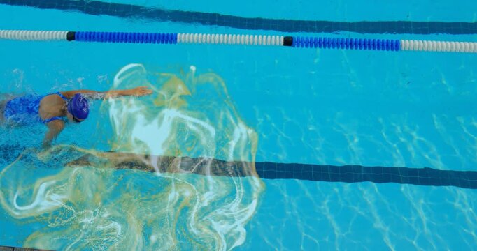 Overhead female swimmer entering frame along lane rope, performing freestyle stroke to train