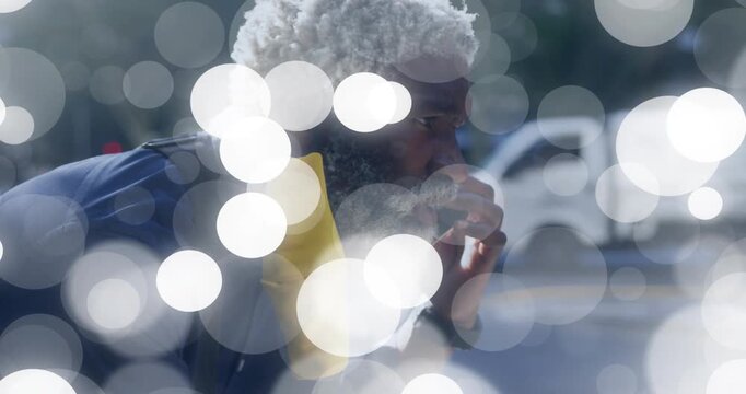 Fitness runner pausing to recover after run on sunny street, bokeh drifting, partly obscuring face