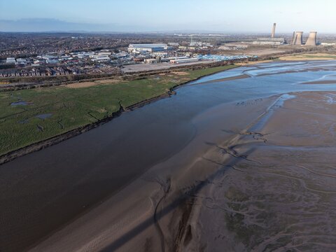 River Mersey Aerial View of Estuary Water and Sunlit Grassland Slopes