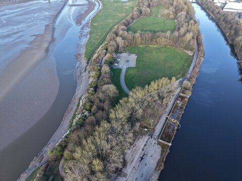 River Mersey Aerial View of Estuary Channel and Sunlit Grassland Landscape