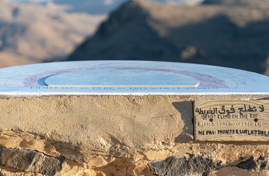 Hermitage of Father de Foucauld Asekrem pinnacle, a circular orientation table at 2780 meters with a handwritten warning sign in arabic and french says "to not climb on the table".