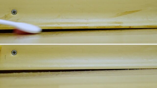 Using toothbrush to refine baseboard edge. Ensuring smooth and even finish on baseboard joint. Gloved hand carefully smoothing baseboard seam for perfect inspection readiness