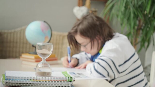 Teenager Student studying doing homework at desk with hourglass, education, knowledge and time management, writing, learning process, exam prep, child training, concentration and discipline sand timer