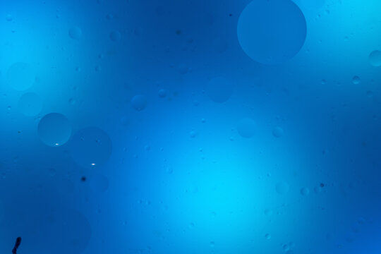 Abstract blue background with oil and water bubbles.