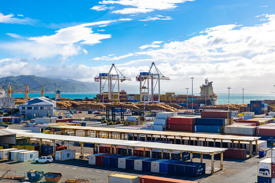 Wellington, New Zealand - 18 February 2026: View of the bustling port where stacks of colorful shipping containers meet the vast expanse of the turquoise sea.