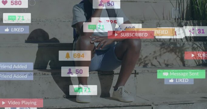 Animation of social media icons over african american boy wearing face mask sitting on the stairs