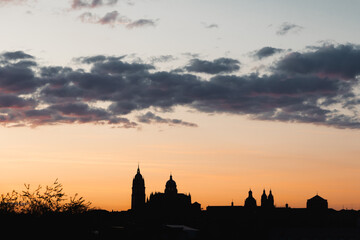 Fototapeta premium Salamanca cathedral skyline silhouetted against a colorful sunset sky, viewing the historic Spanish city architecture during golden hour and twilight evening scene