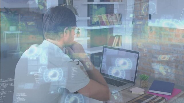 Man sitting at desk in tech office, refocusing on laptop, reviewing data, initiating HUD overlays