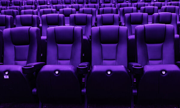 Rows of empty purple cinema seats in modern movie theater