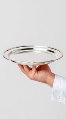 Caucasian male hand holding elegant silver plate against neutral background