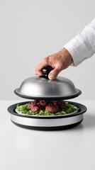 Chef unveiling gourmet dish on platter with meat and greens