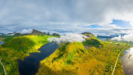 Aerial drone view of misty mountains and fjords in Lofoten, Norway. Atmospheric arctic landscape with fog, moody clouds and scenic northern nature. © biletskiyevgeniy