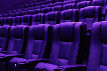 Obraz premium Rows of empty purple cinema seats in modern movie theater