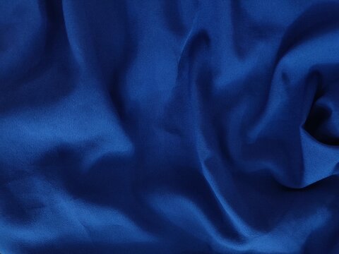 Texture de tissu satin bleu profond avec jeu de lumi&egrave;re et plis &eacute;l&eacute;gants