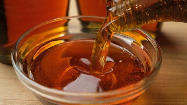 Pouring fresh maple syrup into a glass bowl