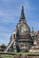 Obraz premium Ancient Khmer-style stone chedi stupa rising above the ruins at Wat Phra Si Sanphet, Ayutthaya Historical Park, Thailand.