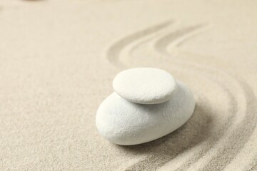 Obraz premium White stones on the sand with patterns. Zen concept. Zen stone garden