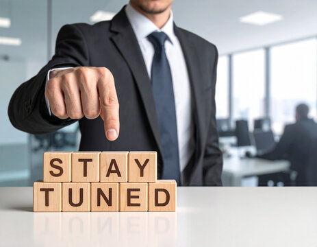 Stay tuned - Geschäftsmann zeigt auf den Text "Stay tuned"