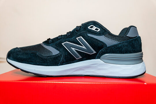 Warsaw, Poland - April 10, 2026: A side view of a New Balance athletic shoe on a red surface, showcasing its sleek design and contemporary style, perfect for sports and lifestyle.
