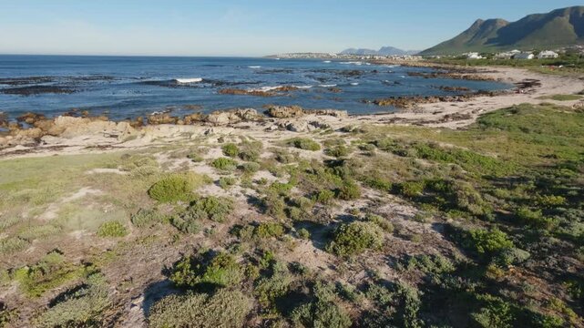 4k 30fps footage of the rugged, rocky Sandbaai coastline near Hermanus, Overberg, Western Cape, South Africa. Lovely view, breaking waves and pristine shoreline for travel and nature storytelling.