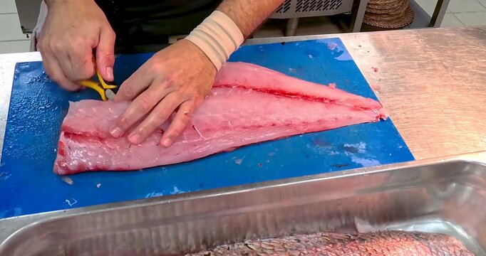Removing Fish Bones with Pliers Tool in Professional Kitchen, Seafood Preparation Technique, Close Up, Unrecognizable People
