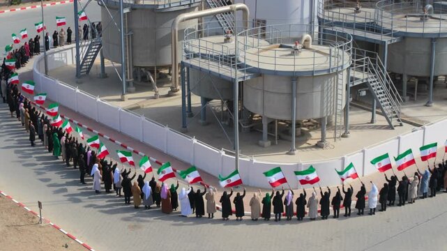 Crowd holding Iranian flags, aerial view of a large gathering demonstrating national pride and unity, Iran.